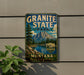 A vintage-style metal sign for Granite State Park, featuring a mountain landscape and a river, mounted on a wall.