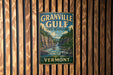 A vintage-style metal sign for the Granville Gulf State Reserve in Vermont, featuring a scenic mountain landscape with a waterfall.
