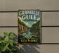 A vintage-style sign for Granville Gulf State Reserve, featuring a scenic mountain landscape with a waterfall, mounted on a wall.