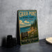 A vintage-style sign for Grass Point State Park in New York, featuring a scenic landscape with pine trees, a beach, and a body of water.