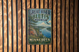 A vintage metal sign for Great River Bluffs State Park in Minnesota, featuring a scenic landscape with a river, mountains, and a bird in flight.