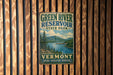 A vintage metal sign for Green River Reservoir State Park in Vermont, featuring a scenic landscape with mountains, trees, and a lake.