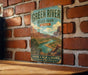 A vintage-style metal sign for Green River State Park in Utah, featuring a scenic illustration of the park's landscape.