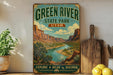 A vintage-style metal sign for Green River State Park in Utah, featuring a scenic illustration of the park's landscape with a river and mountains.