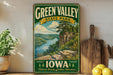 A vintage-style sign for Green Valley State Park in Iowa, featuring a scenic landscape with a river, cliffs, and pine trees.