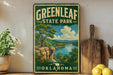 A vintage-style sign for Greenleaf State Park in Oklahoma, featuring a scenic landscape with a river, cliffs, and trees.