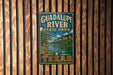 A vintage metal sign for Guadalupe River State Park in Texas, featuring a scenic landscape with a river and mountains.