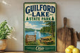 a vintage-style sign for Guilford Lake State Park, with a scenic illustration of a lake, a sailboat, and a picnic area.