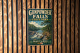 A vintage metal sign for Gunpowder Falls State Park in Maryland, featuring a scenic landscape with a waterfall and forest.