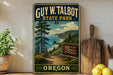 A vintage-style metal sign for Guy W. Talbot State Park in Oregon, featuring a scenic landscape with pine trees, a beach, and a path leading to the park entrance.