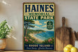 A vintage-style metal sign for Haines Memorial State Park in Rhode Island, featuring a scenic coastal landscape with a beach, ocean, and trees.