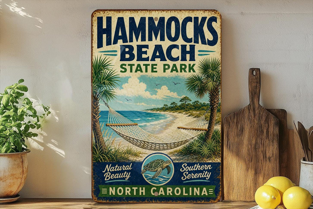 A vintage-style sign for Hammocks Beach State Park in North Carolina, featuring a beach scene with palm trees and a hammock.