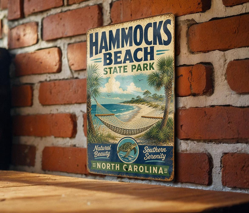 A vintage-style metal sign for Hammocks Beach State Park in North Carolina, featuring a beach scene with palm trees and a hammock.