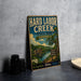 A vintage-style metal sign for Hard Labor Creek State Park in Georgia, featuring a scenic illustration of the park and its surroundings.