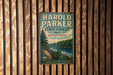 A vintage metal sign for Harold Parker State Forest in Massachusetts, featuring a scenic landscape with a river and pine trees.