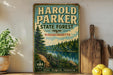 A vintage-style sign for the Harold Parker State Forest in Massachusetts, featuring a scenic illustration of a forest and a lake.