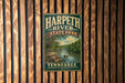 A vintage metal sign for Harpeth River State Park in Tennessee, featuring a scenic image of the river surrounded by lush greenery.