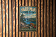 A vintage metal sign for Harriman State Park in New York, featuring a scenic landscape with a lake and mountains.