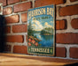 A vintage-style sign for Harrison Bay State Park in Tennessee, featuring a scenic landscape with a lake, mountains, and trees.