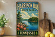 A vintage-style sign for Harrison Bay State Park in Tennessee, featuring a scenic landscape with a lake, mountains, and trees.