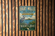 A vintage metal sign for Hart-Miller Island State Park in Maryland, featuring a blue heron and a scenic landscape.