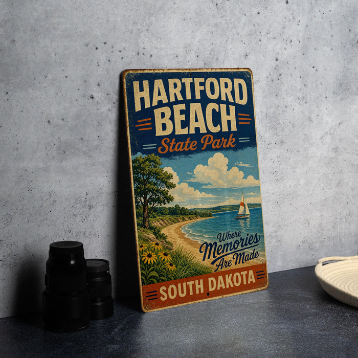 A vintage-style metal sign for "Harford Beach State Park" in South Dakota, featuring a scenic beach landscape with a sailboat and a cloudy sky.