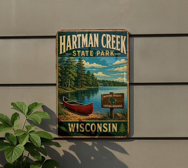 A vintage-style metal sign for Hartman Creek State Park in Wisconsin, featuring a canoe on a lake surrounded by trees.
