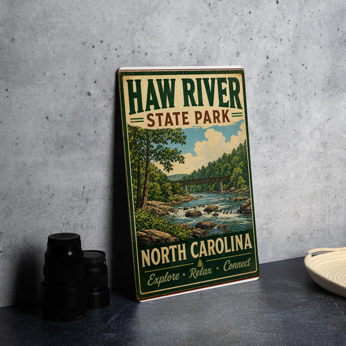 A vintage-style metal sign for Haw River State Park, featuring a scenic illustration of the river and surrounding landscape.