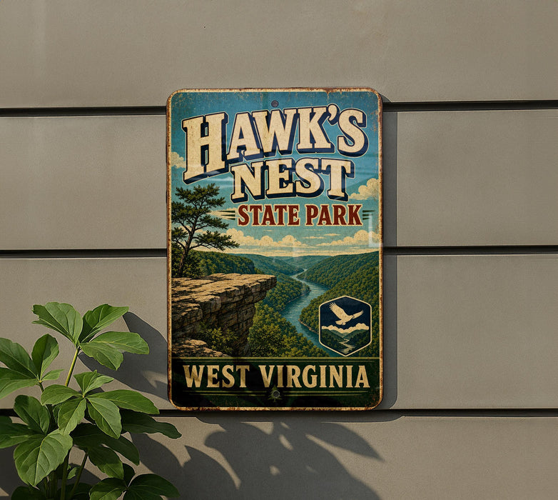 A vintage-style metal sign for Hawk's Nest State Park in West Virginia, featuring a scenic landscape with a cliff, river, and trees.