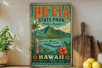 A vintage-style sign for He'e Eia State Park in Oahu, Hawaii, featuring a tropical landscape with mountains, palm trees, and a body of water.
