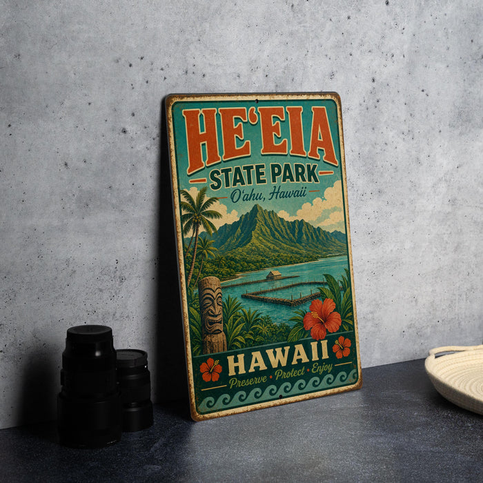 A vintage-style sign for He'eia State Park in Oahu, Hawaii, featuring a tropical landscape with palm trees, mountains, and a tiki statue.