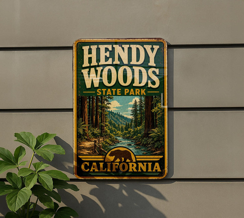 A vintage-style metal sign for HENDY WOODS State Park in California, featuring a scenic image of a forest and a river.