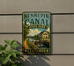 A vintage-style metal sign for Hennepin Canal State Park in Illinois, featuring a scenic illustration of a canal and a bridge.