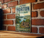 A vintage-style metal sign for Henry Horton State Park in Tennessee, featuring a scenic landscape with a lake and mountains.