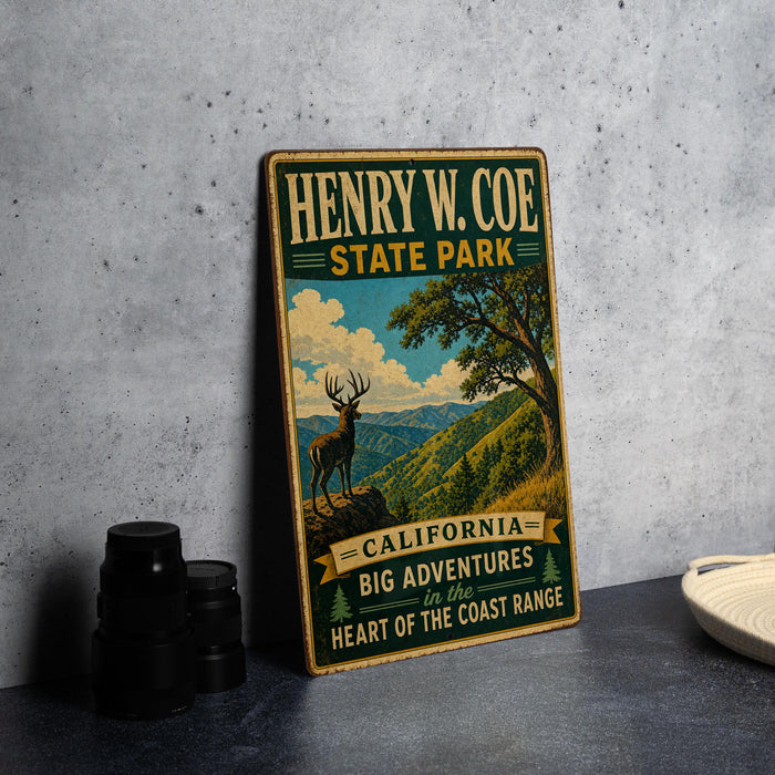 A vintage-style metal sign for Henry W. Coe State Park, featuring an illustration of a deer in a mountainous landscape.