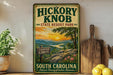 A vintage-style sign for Hickory Knob State Resort Park, featuring a scenic mountain landscape with a sunset.