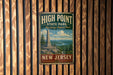 A vintage metal sign for High Point State Park in New Jersey, featuring a scenic image of the park and its landmarks.