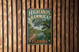 A vintage-style metal sign for Highlands Hammock State Park in Florida, featuring a scenic illustration of a wooden bridge and palm trees.