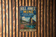 A vintage-style metal sign for Hill Annnex Mine in Minnesota, featuring a scenic illustration of the mine and surrounding landscape.