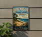 A vintage-style metal sign for Hoffman State Park in Michigan, featuring a scenic beach landscape with a pine tree and a lake.