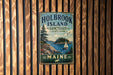 A vintage metal sign for Holbrook Island State Park in Maine, featuring a scenic illustration of a lake, a sailboat, and a forest.