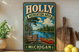 A vintage-style metal sign for the Holly Recreation Area in Michigan, featuring a scenic landscape with a lake, pine trees, and a canoe.