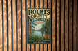A vintage-style metal sign for Holmes County State Park in Mississippi, featuring an illustration of a deer in a forest setting.