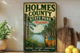 A vintage metal sign for Holmes County State Park in Mississippi, featuring a deer in a natural setting.