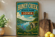 A vintage-style sign for Honey Creek State Park in Iowa, featuring a scenic landscape with a river, cliffs, and wildflowers.