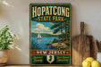 A vintage-style sign for Hopatcong State Park, featuring a scenic image of a sailboat on a lake surrounded by trees and mountains.