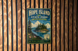 A vintage-style metal sign for Hope Island State Park in Washington, featuring a scenic landscape with pine trees, a lake, and mountains.