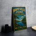 A vintage-style metal sign for Hopeville Pond State Park in Connecticut, featuring a scenic landscape with a lake, pine trees, and mountains.