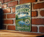 A vintage-style metal sign for Housatonic Meadows State Park in Connecticut, featuring a scenic landscape with a river and mountains.