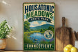 A vintage-style sign for Housatonic Meadows State Park in Connecticut, featuring a scenic landscape with a river and mountains.